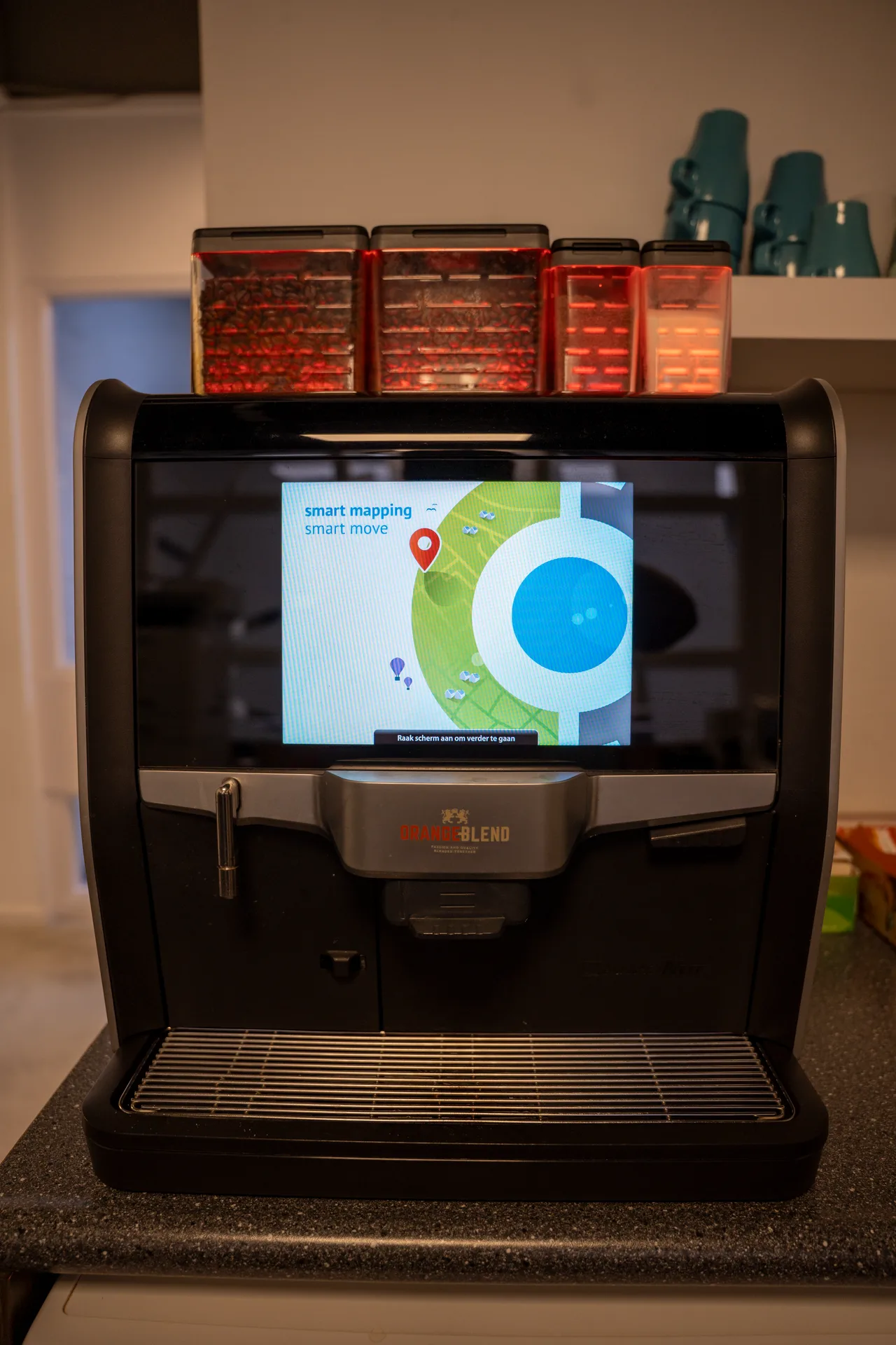 Koffiemachine op het MapGear-kantoor met een kaart op het scherm